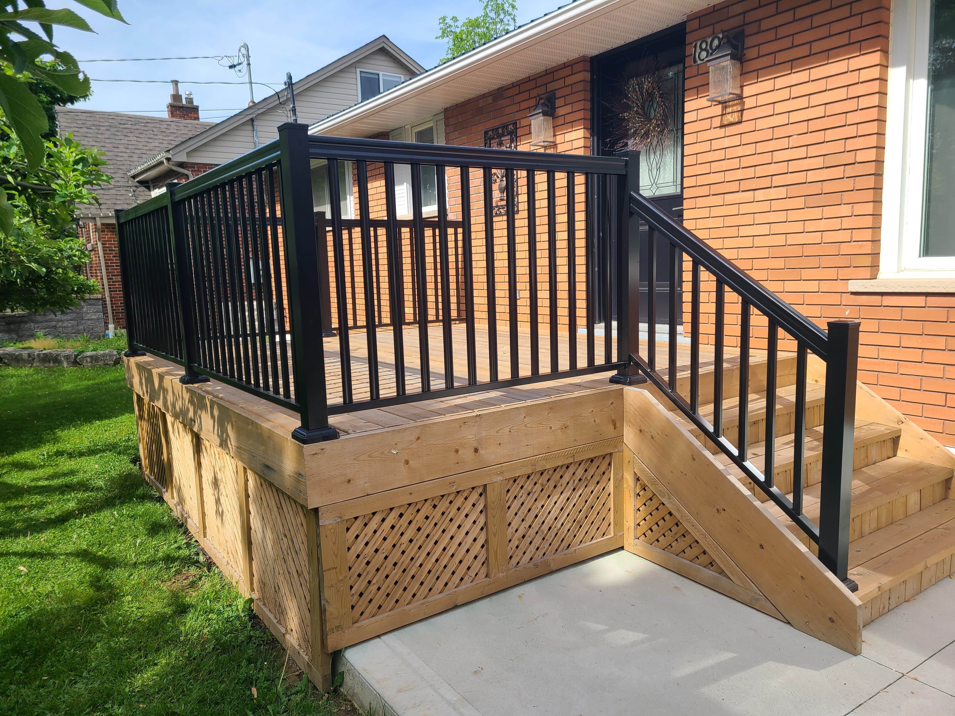 Black aluminum picket railing on wood deck