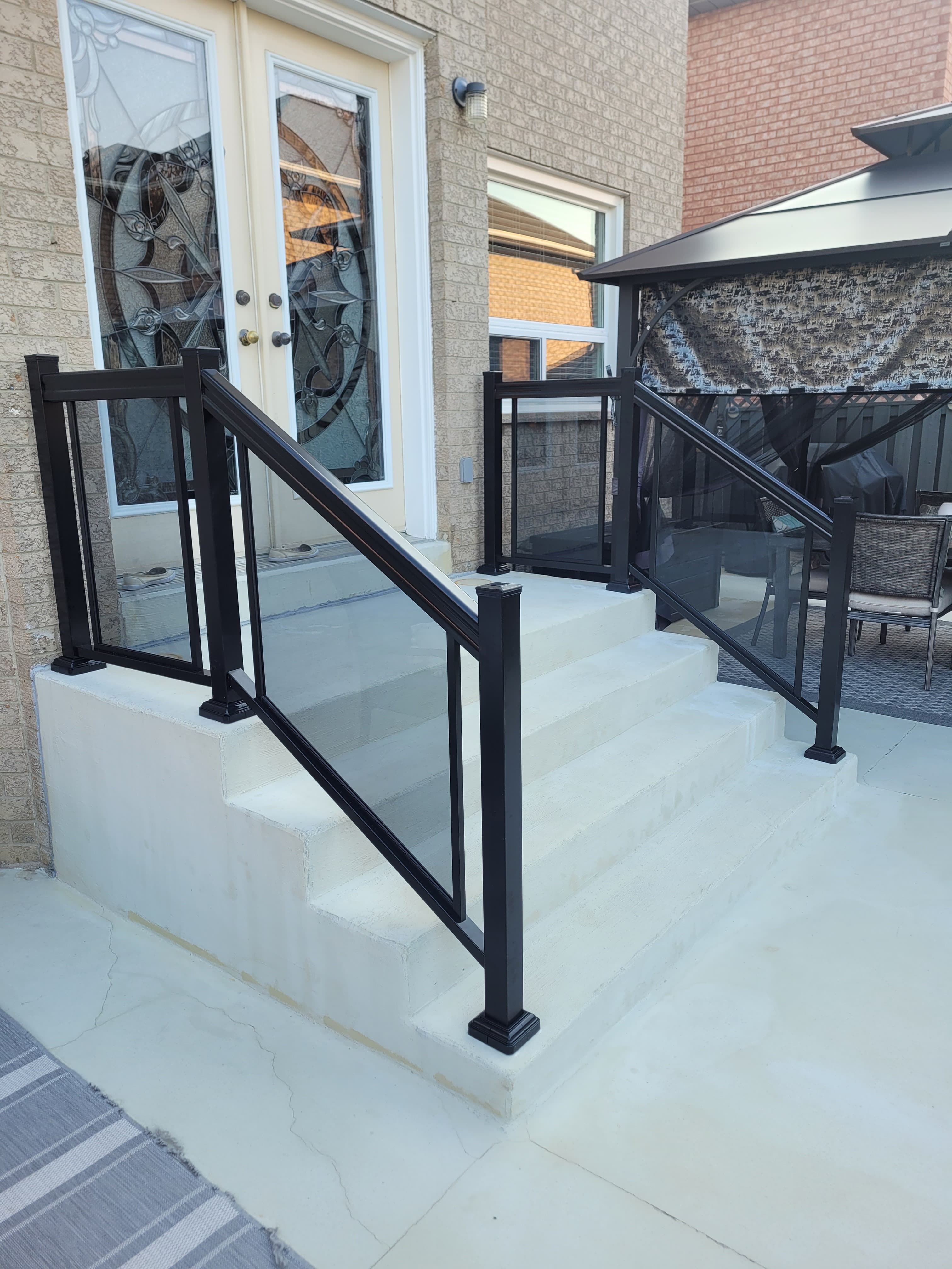 Frameless glass railing on a curved brick staircase