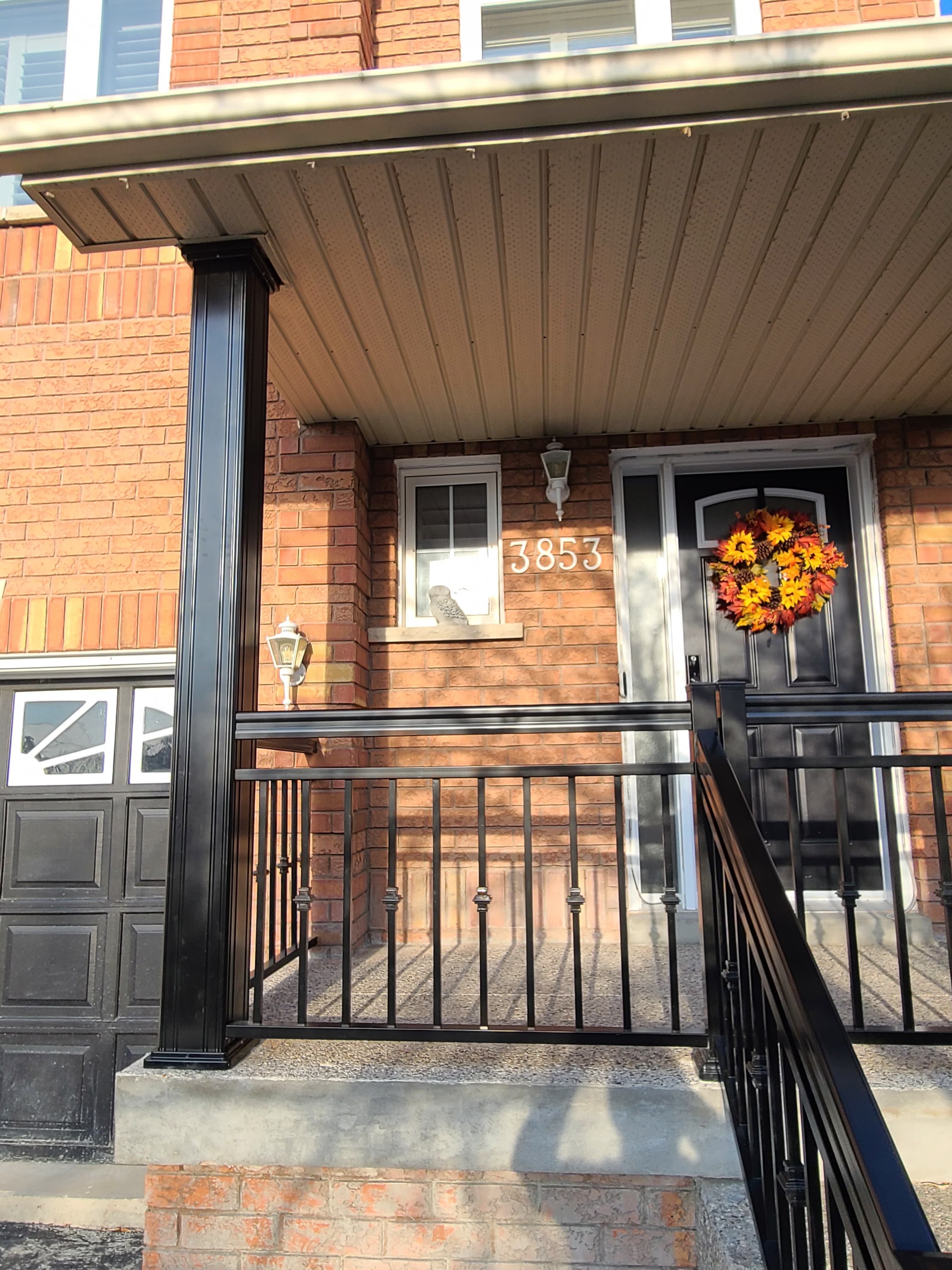 Front entry with black columns and railings