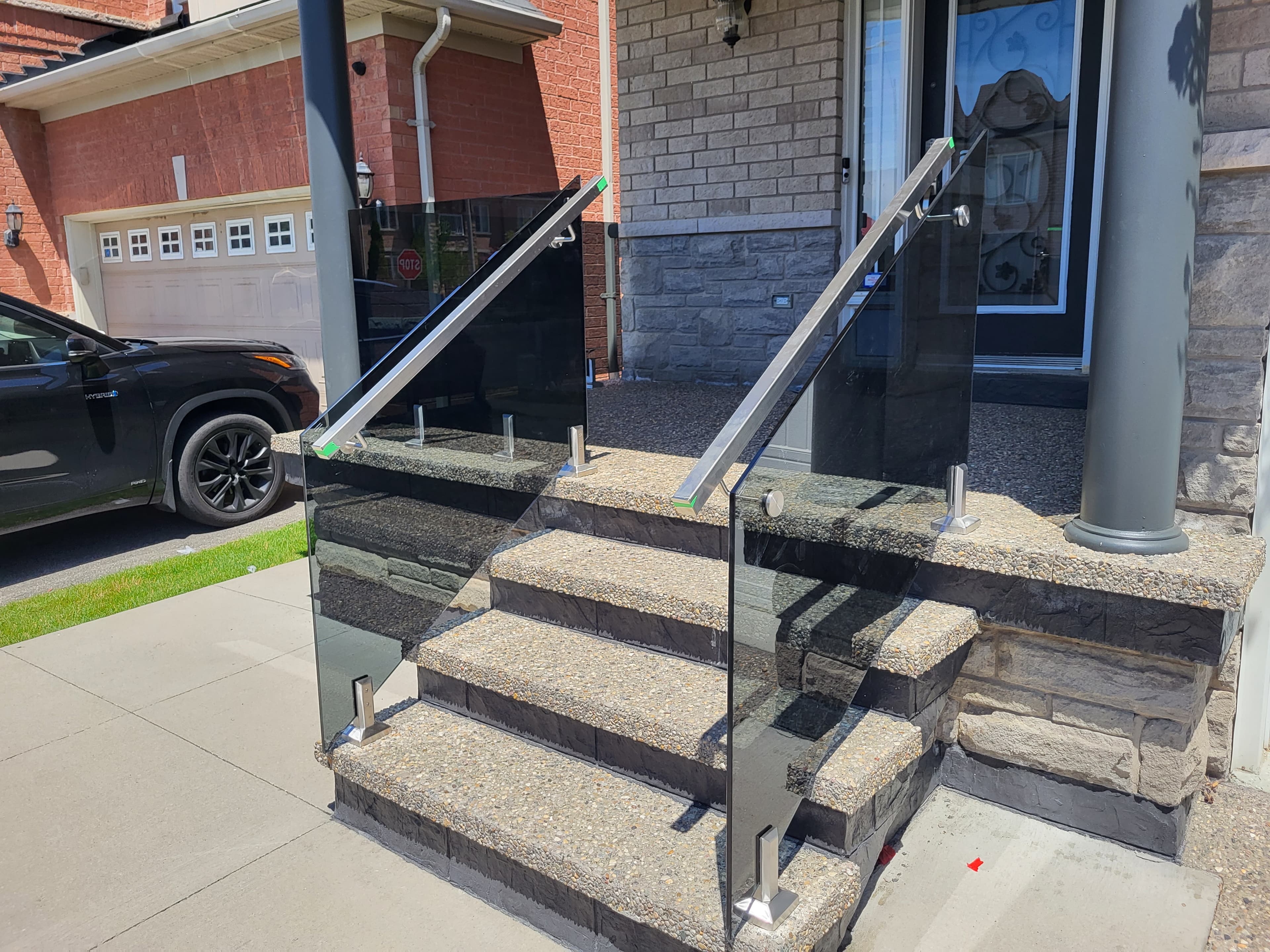 Tinted frameless glass railing on a luxury residential entry
